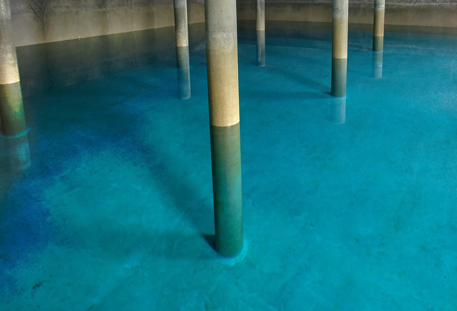Blick ins Innere des Hochbehälters Eichelberg mit tragenden Säulen und klarem Wasser